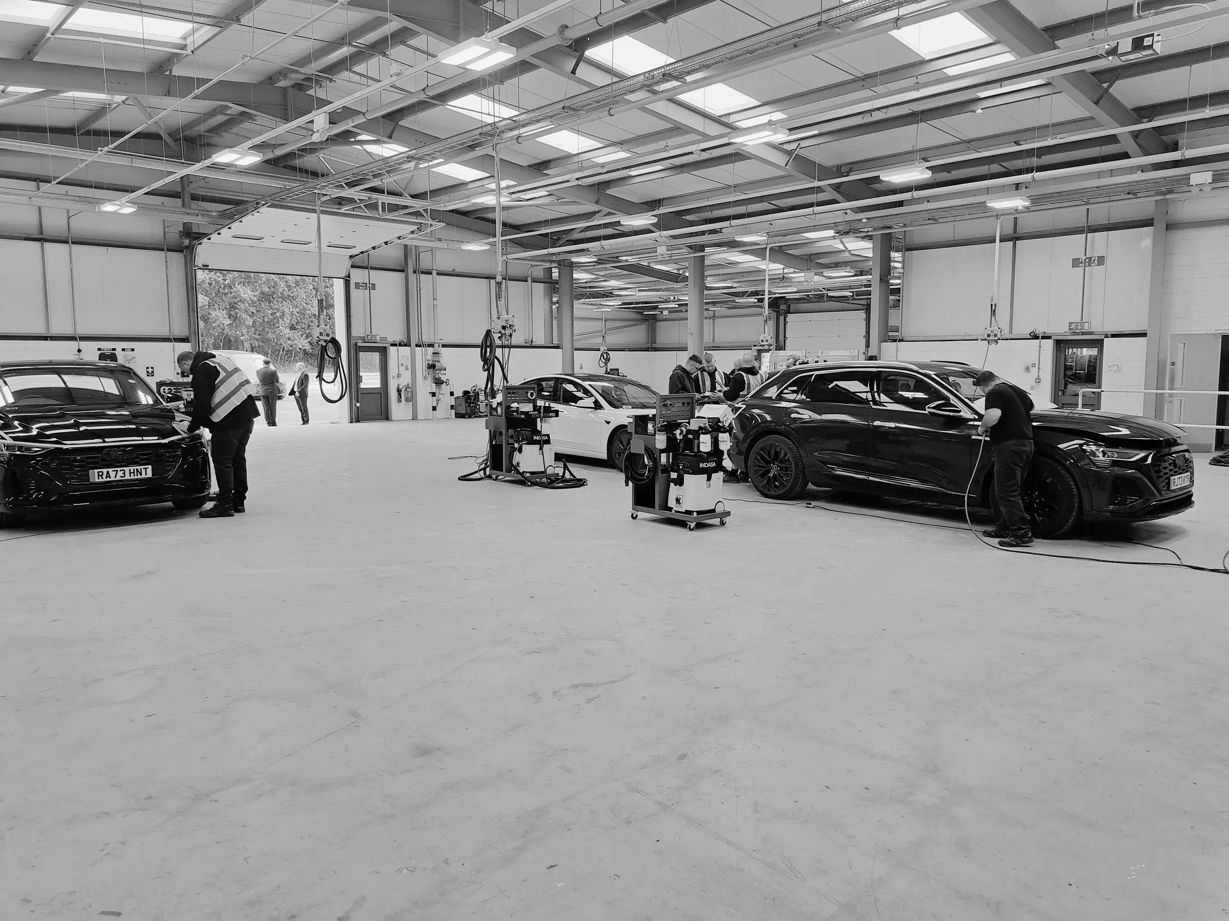 Cover image of cars being worked on in a workshop